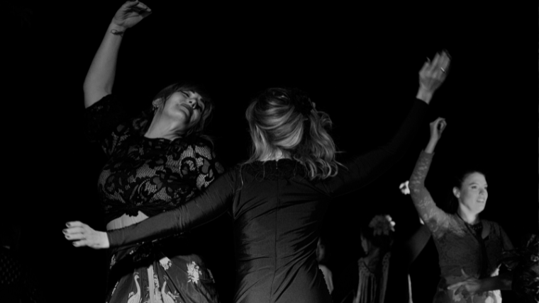 モノクロで女性たちが踊って楽しんでる写真